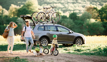 Familie mit zwei kleinen Kindern, die mit dem Auto eine Radtour auf dem Lande machen. - HPIF13968