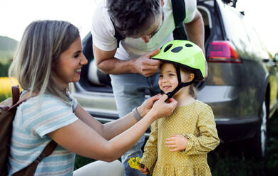 Happy family with small child going on cycling trip in countryside. - HPIF13971