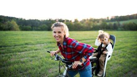 Happy mother with two small daughter on cycling trip, having fun. - HPIF13975