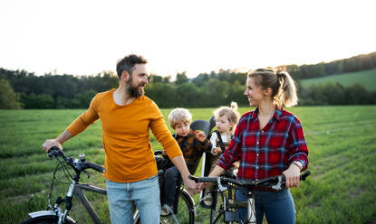 Familie mit zwei kleinen Kindern auf Radtour in der Natur, beim Ausruhen. - HPIF13976