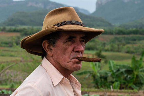 Tobacco plantation worker with cigar, on valley ridge, Vinales, Cuba, West Indies, Caribbean, Central America - RHPLF23916
