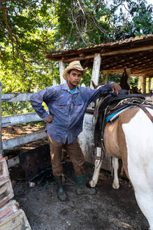 Cowboy mit seinem Pferd auf einer Farm bei Trinidad, Kuba, Westindien, Karibik, Mittelamerika - RHPLF23925