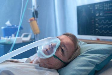 Close-up of covid-19 infected patient in bed in hospital, coronavirus and ventilation concept. - HPIF14003
