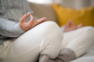Midsection von unerkennbaren Frau drinnen zu Hause tun Yoga, auf dem Sofa, geistige Gesundheit und Meditation Konzept. - HPIF14016