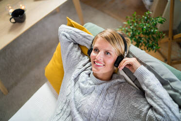 Oben Ansicht Porträt der Frau mit Kopfhörern entspannen drinnen zu Hause, psychische Gesundheit Konzept. - HPIF14024