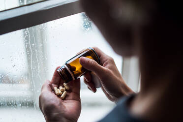 Depressive Frau mit Pillen drinnen zu Hause, psychische Gesundheit und Drogenabhängigkeit Konzept. - HPIF14027