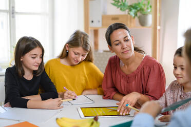 Eine Gruppe von Kindern, die zu Hause unterrichtet werden, mit einem Lehrer, der drinnen lernt, Konzept des Coronavirus. - HPIF14040