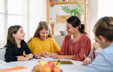 Eine Gruppe von Kindern, die zu Hause unterrichtet werden, mit einem Lehrer, der drinnen lernt, Konzept des Coronavirus. - HPIF14041