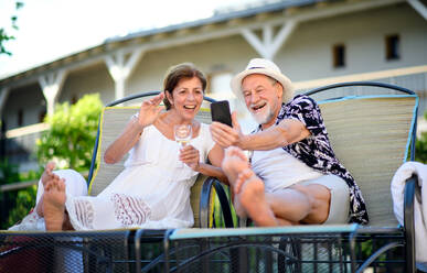 Fröhliches älteres Paar mit Smartphone im Freien im Urlaub, Videoanrufkonzept. - HPIF14080