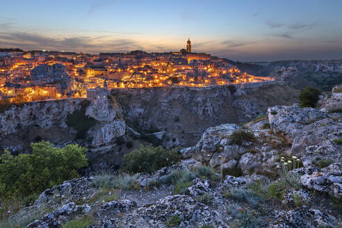 Abenddämmerung über der Schlucht des Flusses Gravina und der beleuchteten Altstadt von Sassi di Matera, UNESCO-Weltkulturerbe, Matera, Basilikata, Italien, Europa - RHPLF23973