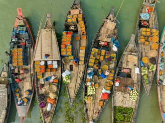 Aerial view of people trading with fruits and vegetables on boats along the river in Dhaka, Bangladesh. - AAEF17896