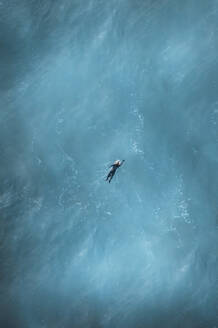 Luftaufnahme von Constantine Bay mit Blick von oben auf einen Surfer im Meer, Cornwall, Vereinigtes Königreich. - AAEF17915