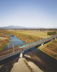 Luftaufnahme des Tohoku Shinkansen Hochgeschwindigkeitszuges auf einer Brücke, Tochigi, Japan. - AAEF17950
