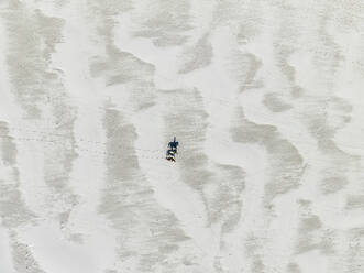 Luftaufnahme einer Person, die auf einem Pferd am Strand entlang reitet, Kapstadt, Südafrika. - AAEF17991