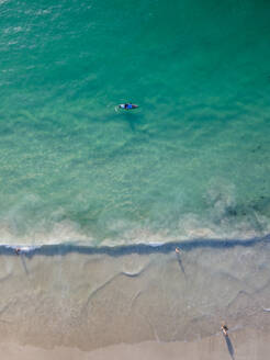 Luftaufnahme von Menschen beim Surfen im Meer in Camps Bay, Kapstadt, Südafrika. - AAEF18003