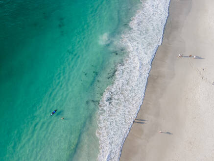 Luftaufnahme von Menschen beim Surfen im Meer in Camps Bay, Kapstadt, Südafrika. - AAEF18004