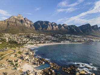 Luftaufnahme von Menschen beim Surfen im Meer in Camps Bay, Kapstadt, Südafrika. - AAEF18007