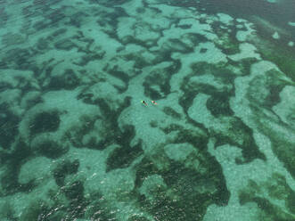 Aerial view of two surfers in Tanjung Aan Beach, Kuta Lombok, Indonesia. - AAEF18016