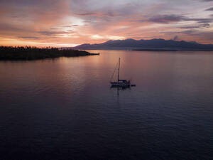 Aerial view of sailing vessels during golden hour anchoring near Tobelo, Halmahera, Indonesia. - AAEF18044