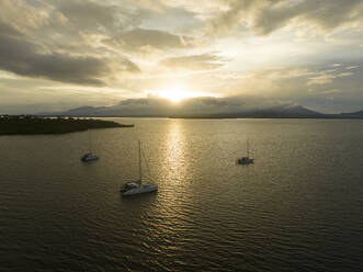 Aerial view of sailing vessels during golden hour anchoring near Tobelo, Halmahera, Indonesia. - AAEF18046