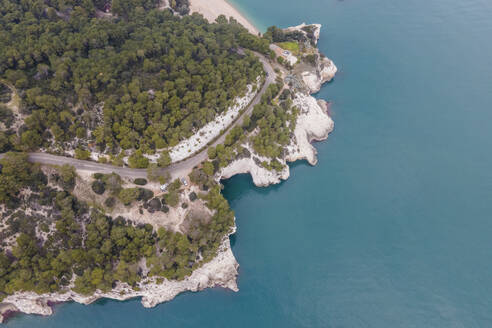 Luftaufnahme einer Straße entlang der wilden Küstenlinie mit natürlichen Bögen, Vieste, Naturpark Gargano, Apulien, Italien. - AAEF18104