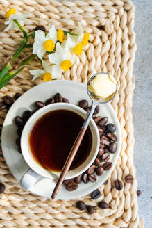 Tasse kugelsicherer Keto-Kaffee, serviert auf einem Betontisch am sonnigen Morgen - ADSF44062