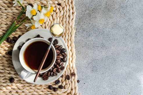 Tasse kugelsicherer Keto-Kaffee, serviert auf einem Betontisch am sonnigen Morgen - ADSF44063