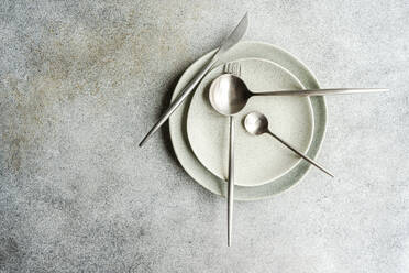Minimalistic table setting with tableware and cutlery on concrete background - ADSF44068