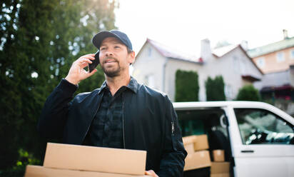 Ein Kurier liefert mit seinem Smartphone ein Paket in der Stadt aus. - HPIF14109