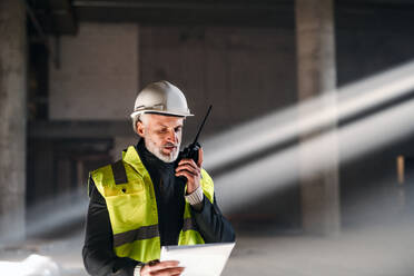 Zusteller mit Gesichtsmaske, Helm und Smartphone bei der Auslieferung von Paketen in der Stadt. - HPIF14120