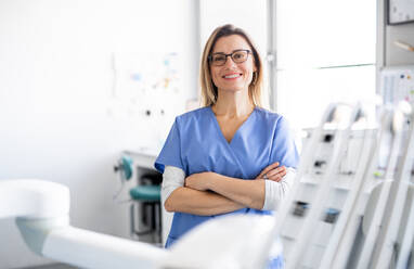 Porträt einer Zahnarzthelferin in einer modernen Zahnarztpraxis in der Vorderansicht, die in die Kamera schaut. - HPIF14173
