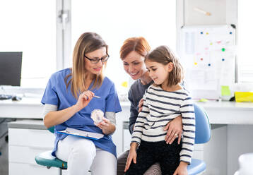 Ein kleines Mädchen, Mutter und Zahnarzt in der Praxis, eine zahnärztliche Untersuchung. - HPIF14187