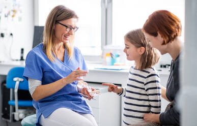 A small girl, mother and dentist in surgery, a dental checkup. - HPIF14189