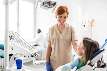 Eine weibliche Zahnärztin im Gespräch mit einer Frau in der Zahnarztpraxis, jährliche Kontrolluntersuchung. - HPIF14193