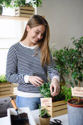 Young woman working at home, plant care concept. Coronavirus concept. - HPIF14313