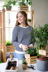 Young woman working at home, plant care concept. Coronavirus concept. - HPIF14314