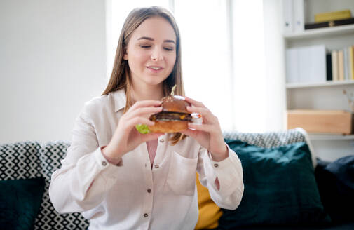 Frontansicht einer jungen Frau mit Tablet, die zu Hause Essen bestellt, Konzept für Coronavirus und Essenslieferung. - HPIF14338