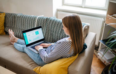 Junge Studentin mit Laptop bei der Arbeit zu Hause, Coronavirus-Konzept. - HPIF14342