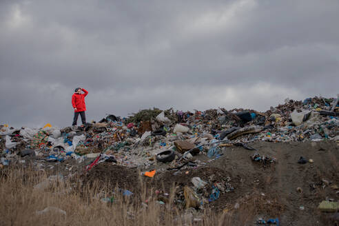 Mann stehend und in die Ferne blickend auf Mülldeponie, Umweltkonzept, Raum kopieren. - HPIF14395