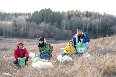 Group of activists picking up litter in nature, environmental pollution and plogging concept. - HPIF14403