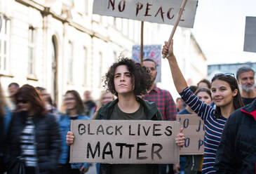Black lives matters protesters holding signs and marching outdoors in city streets. - HPIF14430