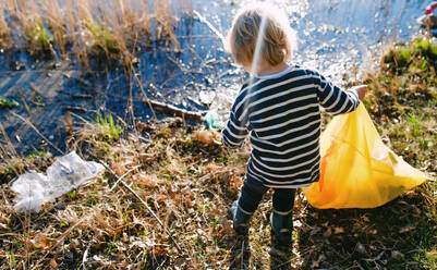 Midsection von unerkennbar kleines Kind sammeln Müll im Freien in der Natur, plogging Konzept. - HPIF14449