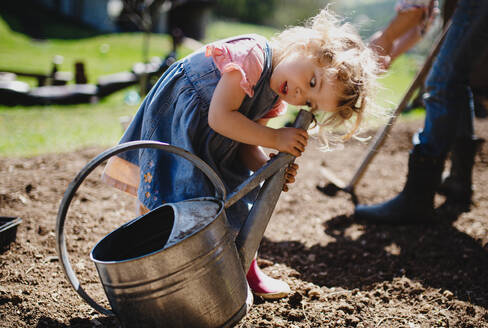 Kleines Mädchen spielt im Freien im Garten, Gartenarbeit und nachhaltigen Lebensstil Konzept. - HPIF14482