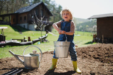 Glücklicher kleiner Junge bei der Arbeit im Garten, nachhaltiges Lebensstilkonzept. - HPIF14484