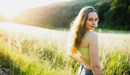 Portrait of young teenager girl outdoors in nature at sunset. Copy space. - HPIF14617