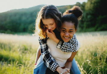 Front view of cheerful young teenager girls friends outdoors in nature, having fun. - HPIF14658