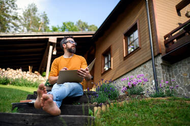 Porträt eines reifen Mannes, der im Garten arbeitet, Home-Office-Konzept. - HPIF14848