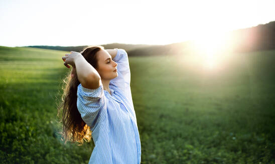Porträt eines jungen Mädchens in der Natur auf einer Wiese bei Sonnenuntergang. - HPIF14851