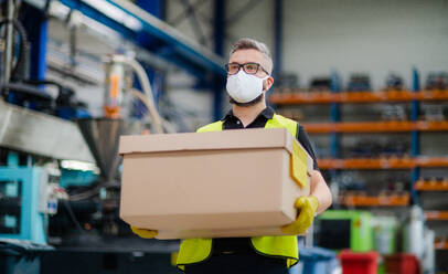 Portrait of man worker with protective mask working in industrial factory or warehouse. - HPIF15012