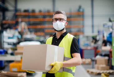 Portrait of man worker with protective mask working in industrial factory or warehouse. - HPIF15013